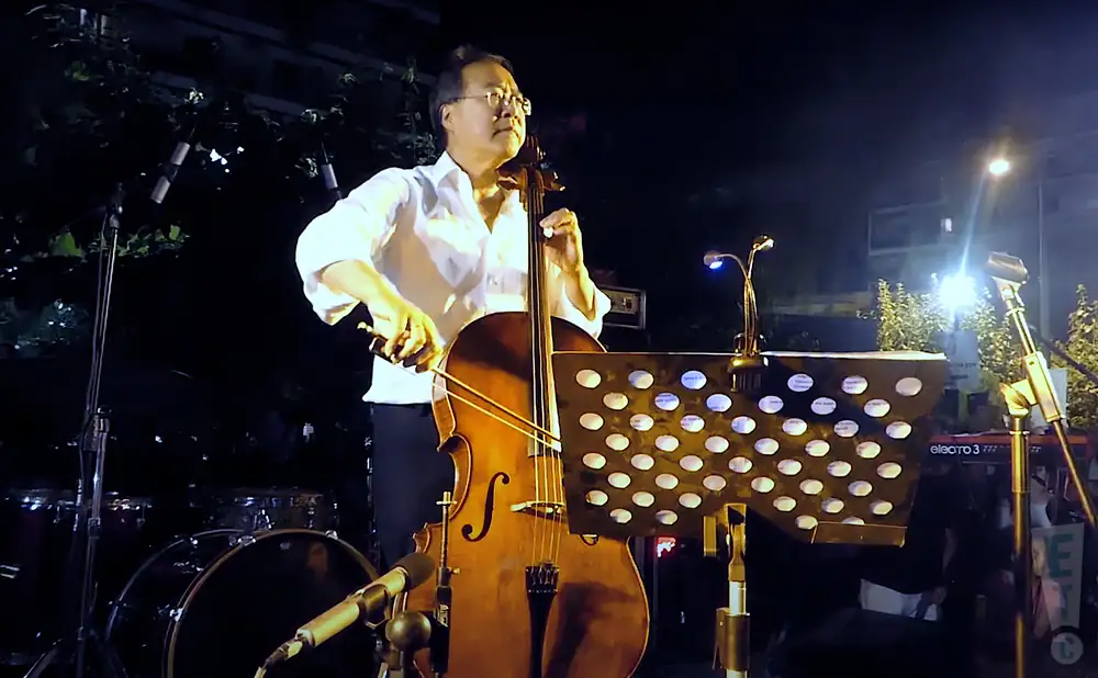 a rear view picture of rock star yoyo ma performing on stage to a large audience